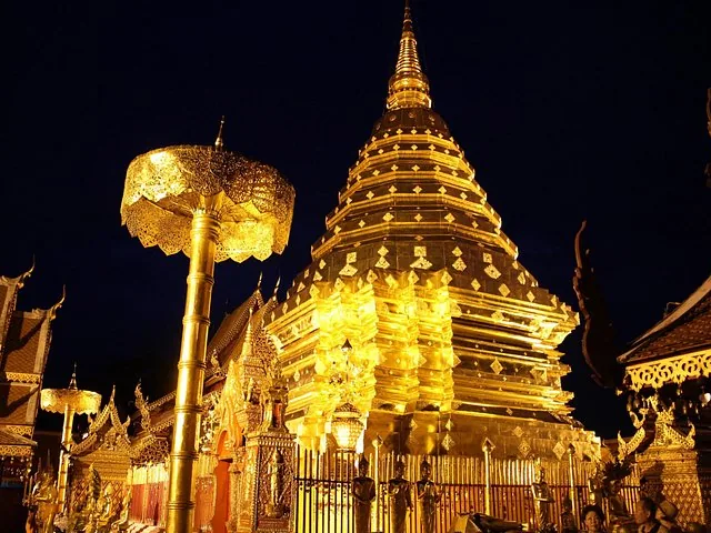 Golden pagoda and umbrella at Wat Phra That Doi Suthep illuminated at night